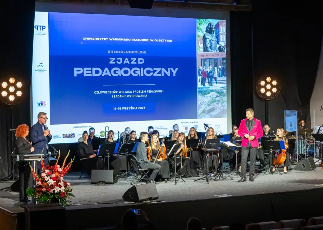 Zjazd pedagogiczny: na scenie orkiestra muzyczna z dyrygentem 