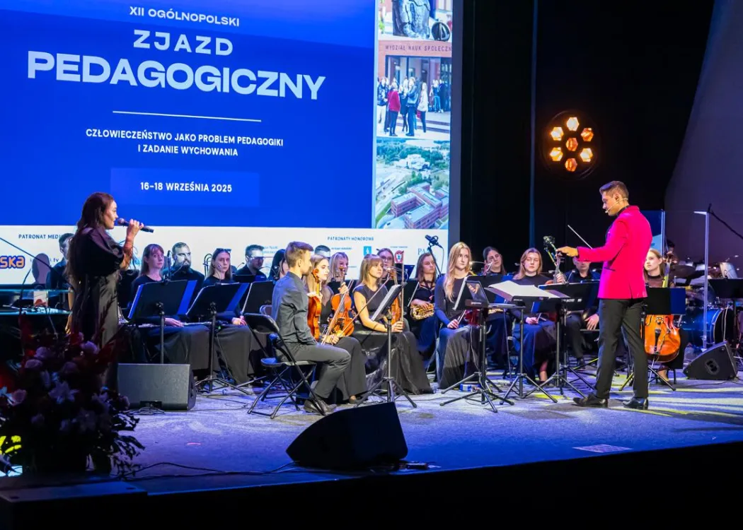 Zjazd pedagogiczny: na scenie orkiestra muzyczna z dyrygentem 