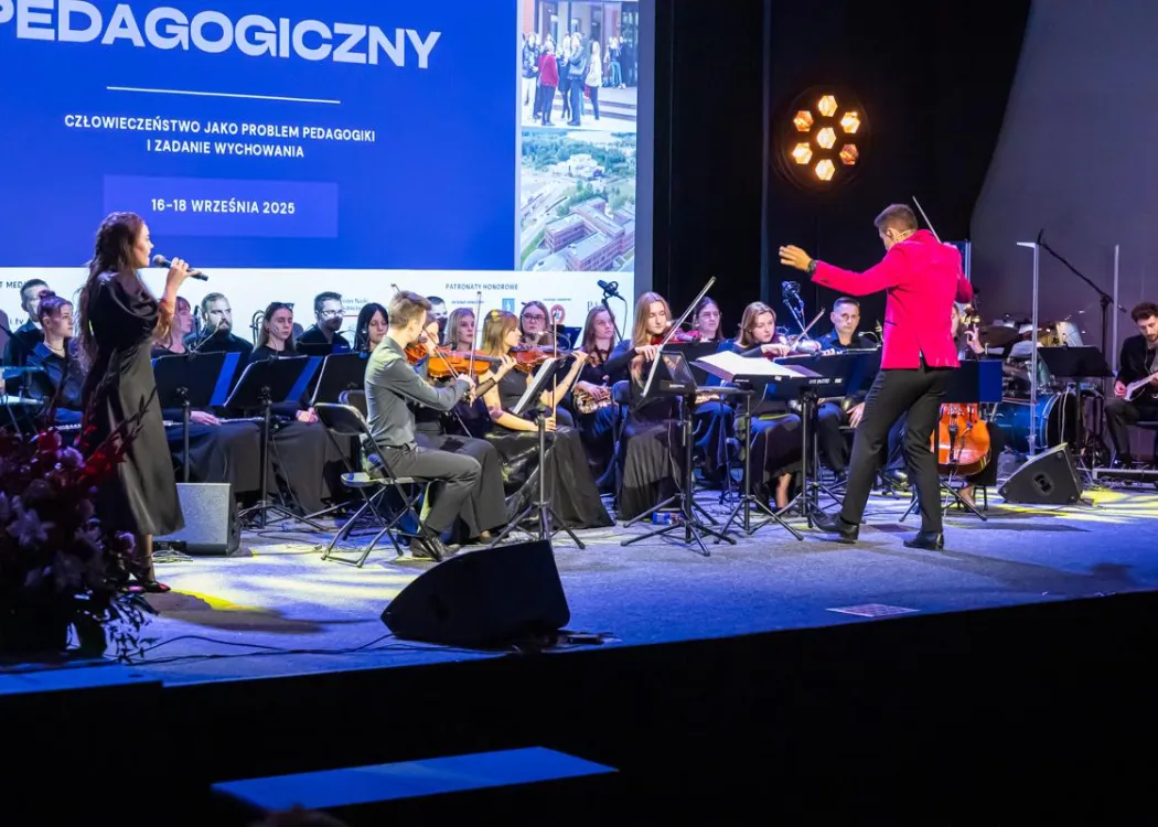 Zjazd pedagogiczny: na scenie orkiestra muzyczna z dyrygentem 