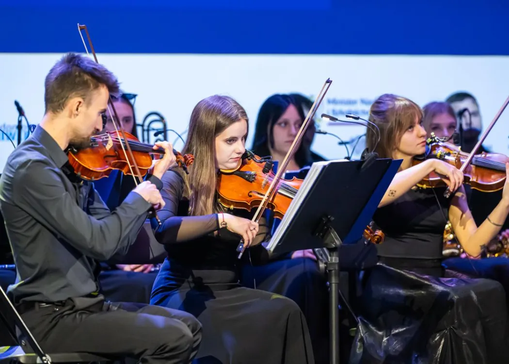 Zjazd pedagogiczny: na scenie orkiestra muzyczna, skrzypce