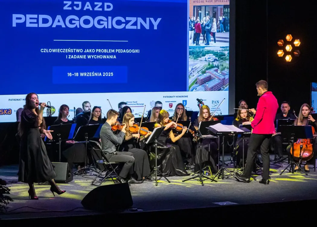 Zjazd pedagogiczny: na scenie orkiestra muzyczna z dyrygentem 