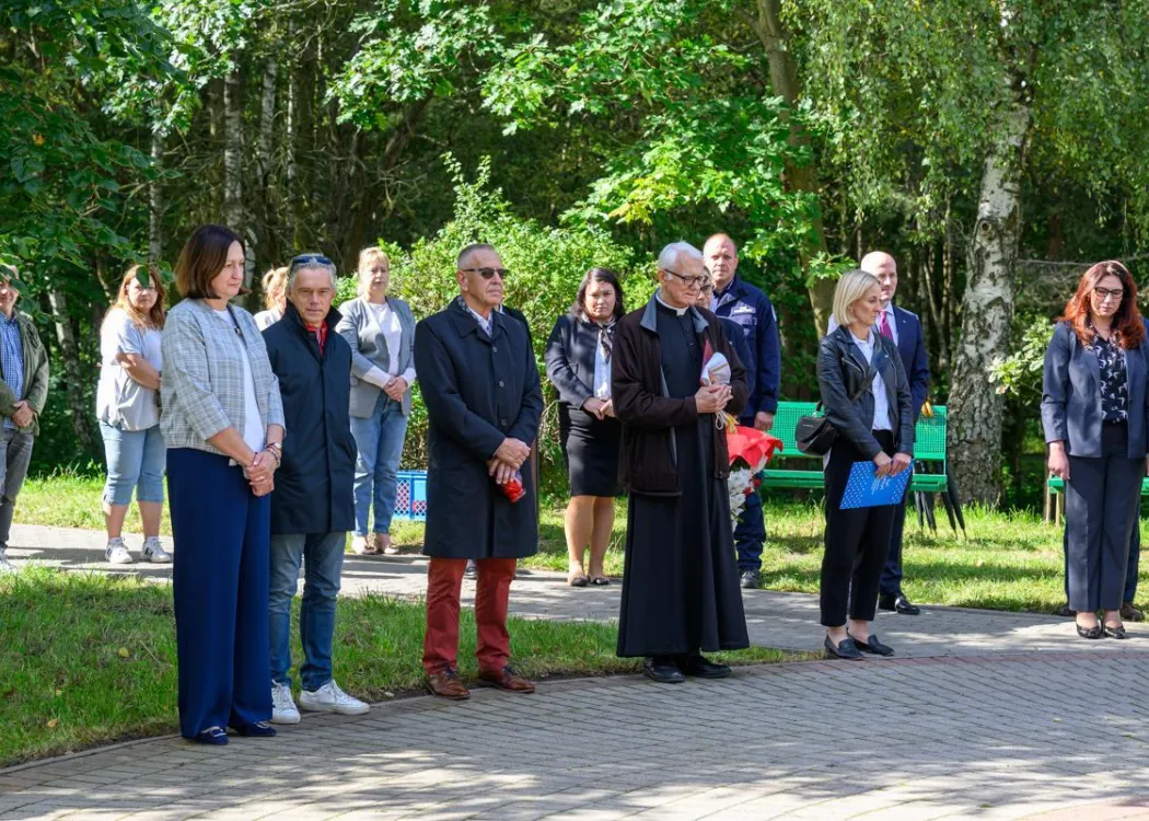 zgromadzeni ludzie stoją i słuchają 