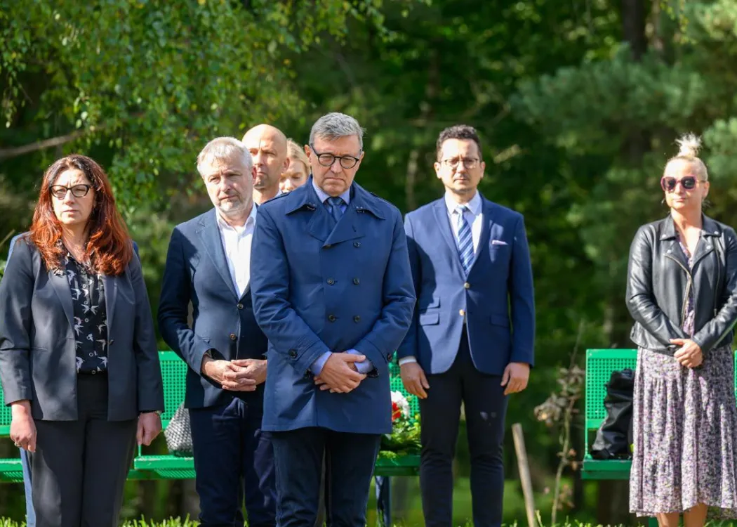 Rektor stoi w otoczeniu współpracowników 