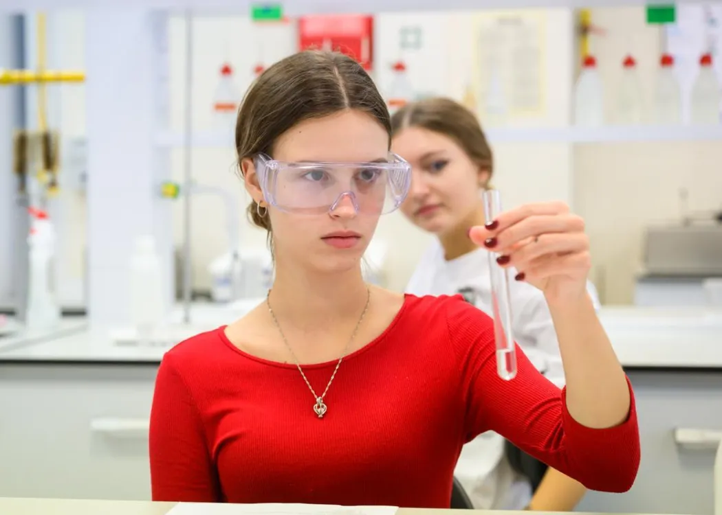 Młodzież polonijna na obozie medycznym: zajęcia w laboratorium, dziewczyna w czerwonej bluzce