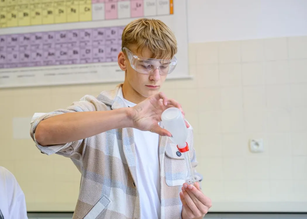 Młodzież polonijna na obozie medycznym: zajęcia w laboratorium, chłopak z butelką