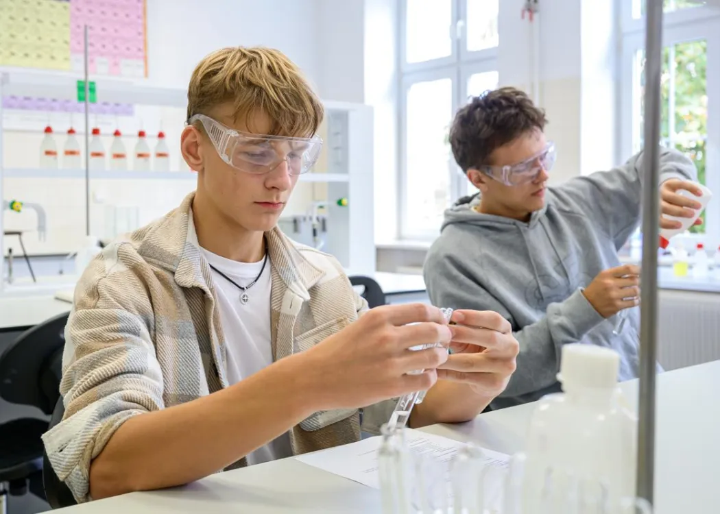 Młodzież polonijna na obozie medycznym: zajęcia w laboratorium, dwóch chłopców z próbówkami