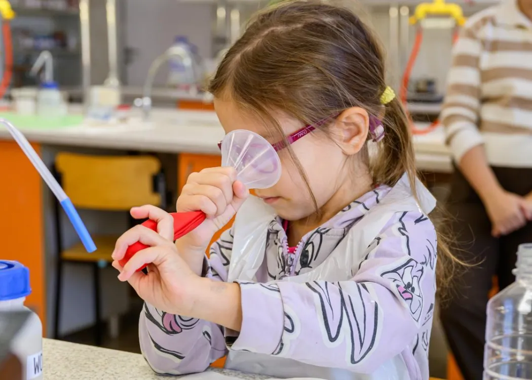 Olsztyńskie Dni Nauki i Sztuki 2025: dziewczynka wykonująca eksperymenty podczas warsztatów