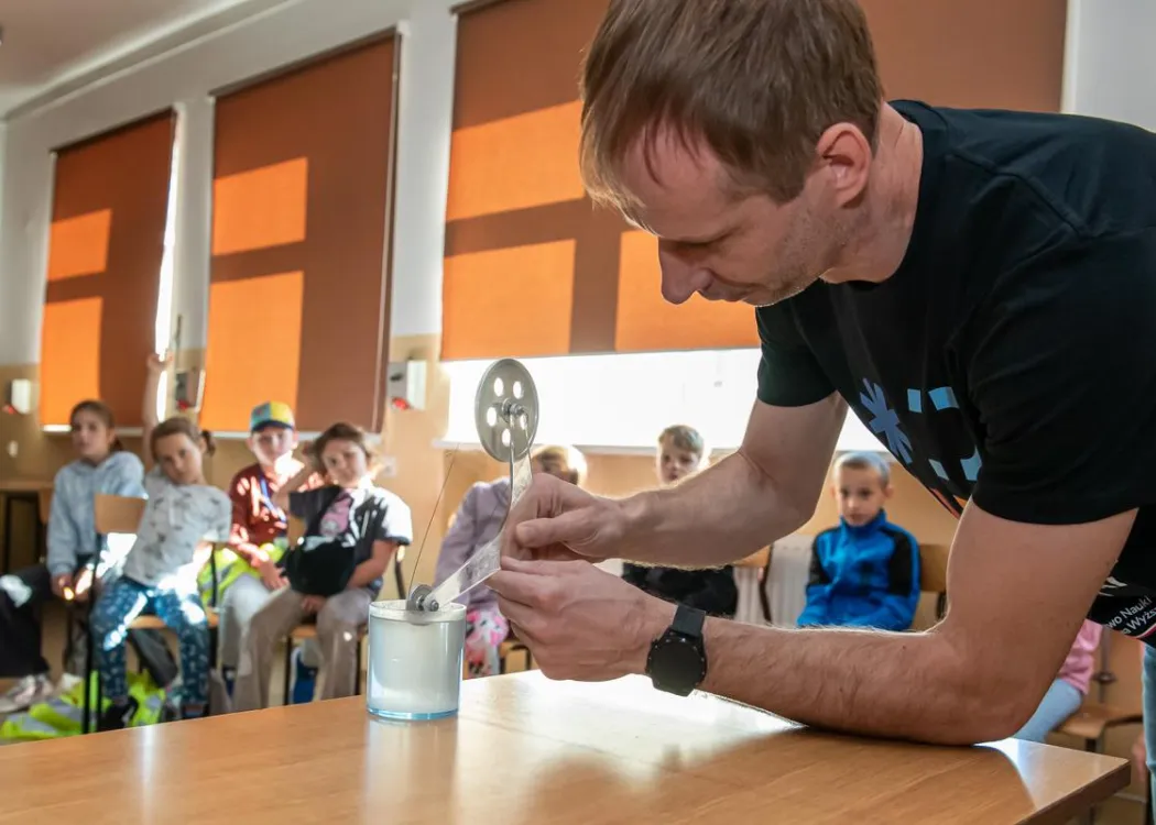 Olsztyńskie Dni Nauki i Sztuki 2025: prowadzący prezentuje eksperyment podczas warsztatów