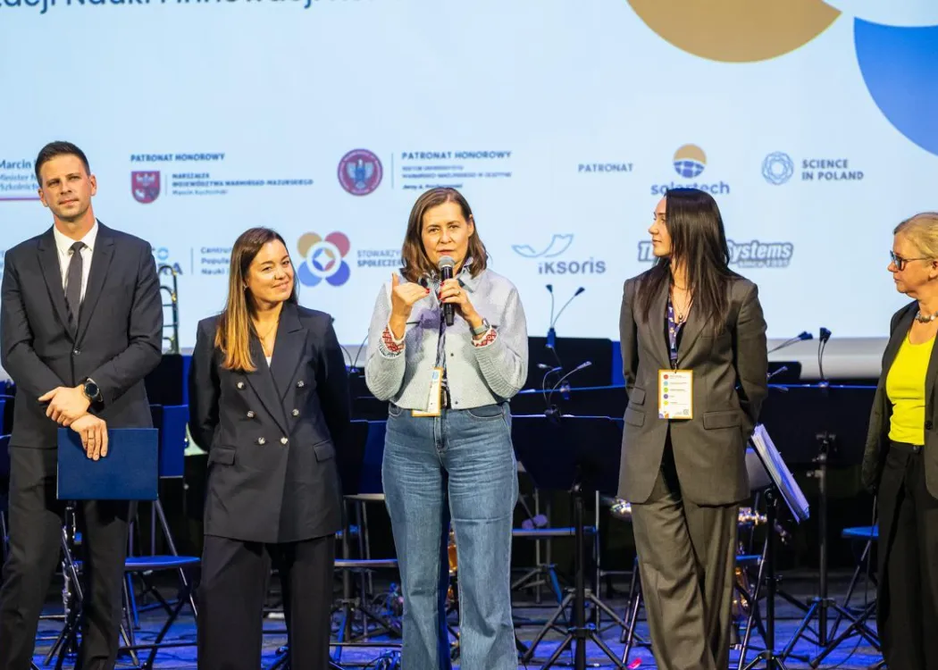 Konferencja SPIN: organizatorzy stoją na scenie. Przemawia Dorota Sawicka