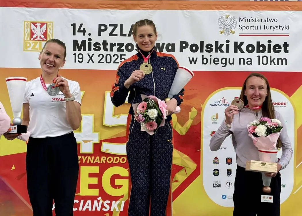 Aleksandra Lisowska na najwyższym stopniu podium pozuje z medalem. Obok niej  Elżbieta Glinka i Izabela Paszkiewicz
