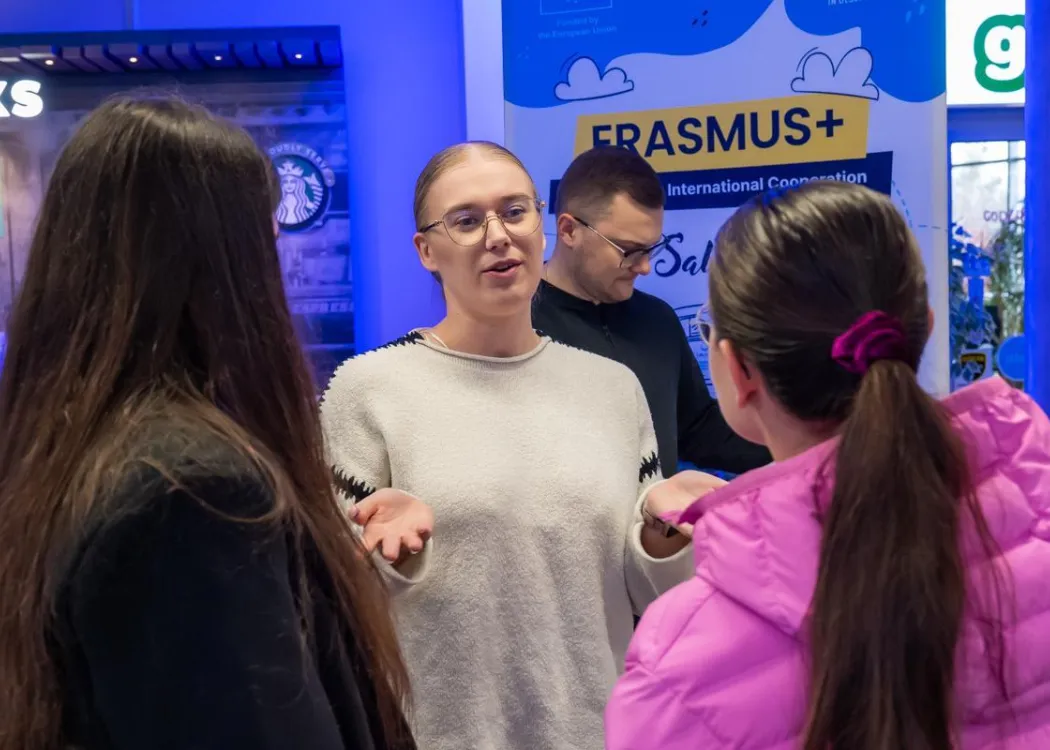 Student EXPO 2025: uczestniczka rozmawia z odwiedzającymi 