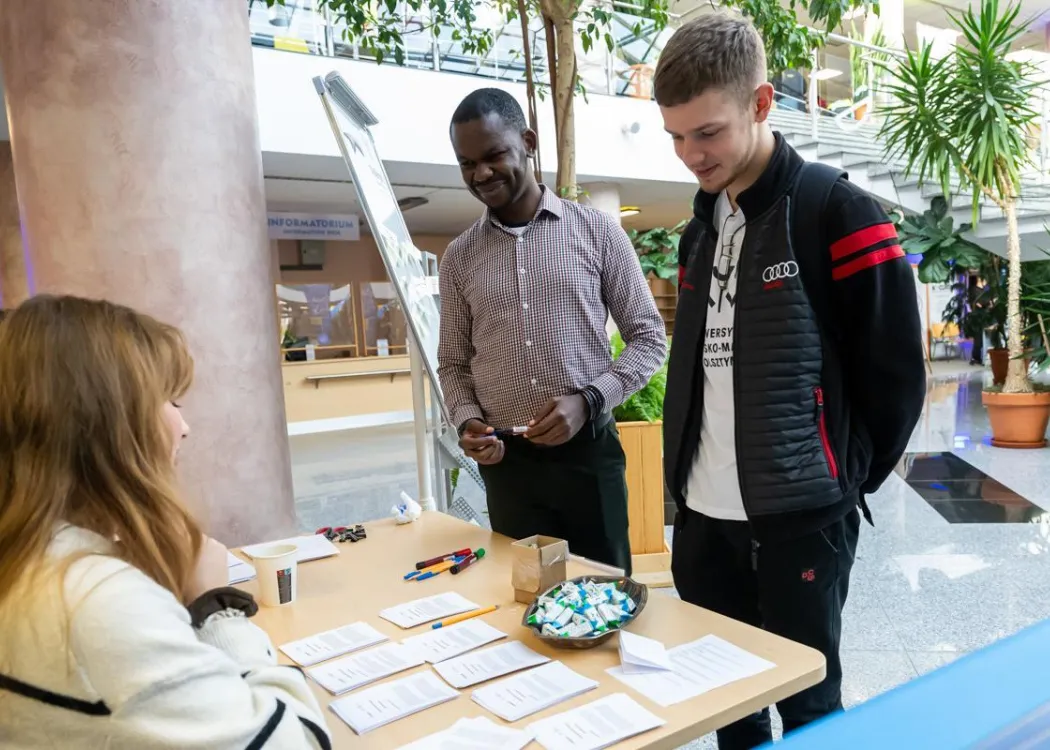Student EXPO 2025: ambasador ChallengeEU Temitope Francis rozmawia z jednym z odwiedzających stoisko sojuszu 