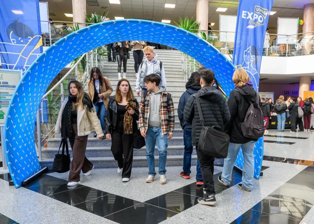Student EXPO 2025: studenci przechodzą pod banerem z logo UWM 