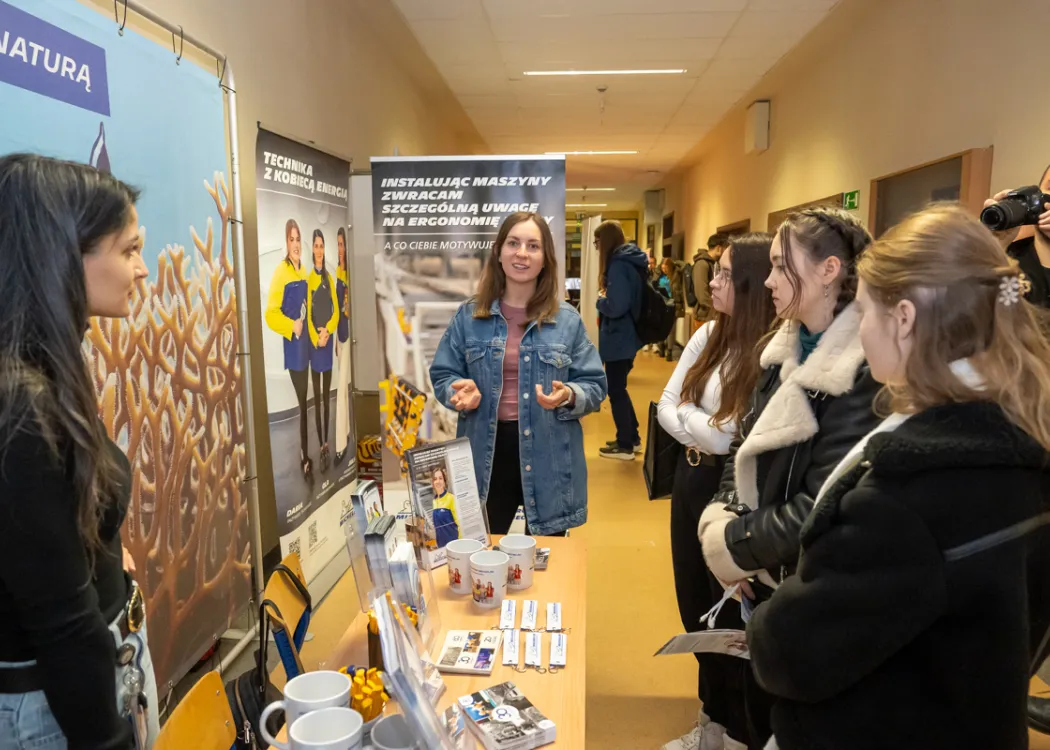 studenci stoją naprzeciwko stoiska Michelin i zbierają informacje o firmie