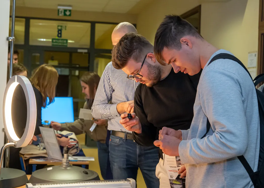 studenci pochylający się nad jednym ze stanowisk