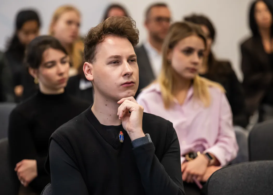 osoby siedzą i słuchają wystąpień