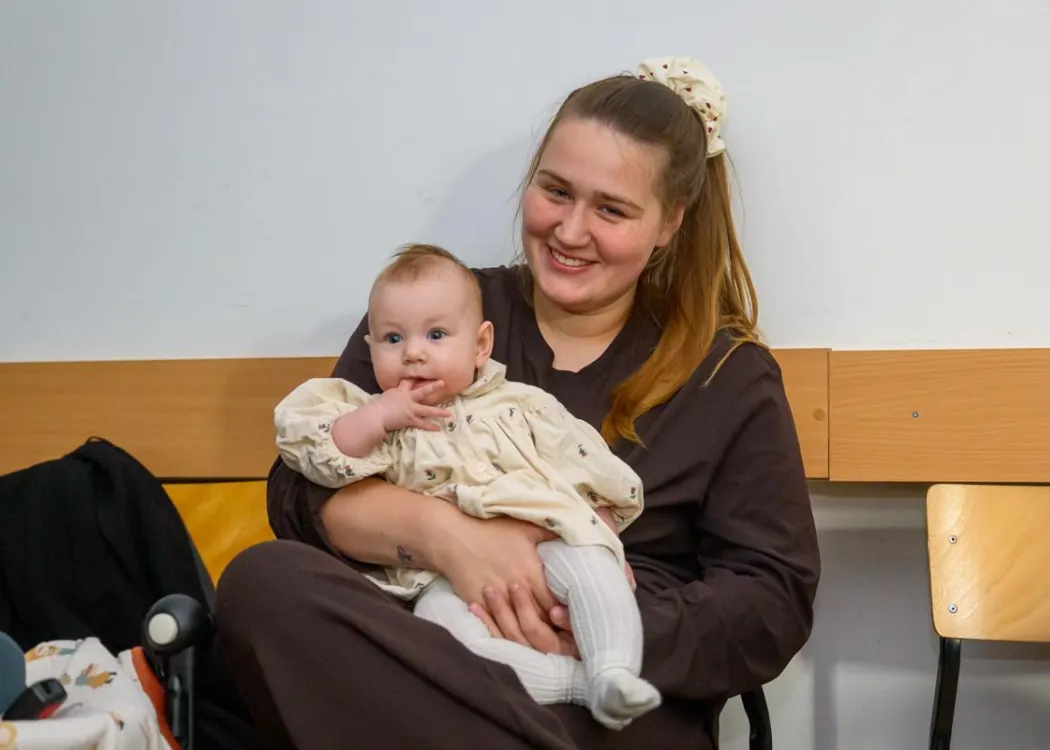 II Warmińsko-Mazurskie Seminarium dla Położnych i Studentów: uczestniczka seminarium trzyma na rękach małe dziecko 