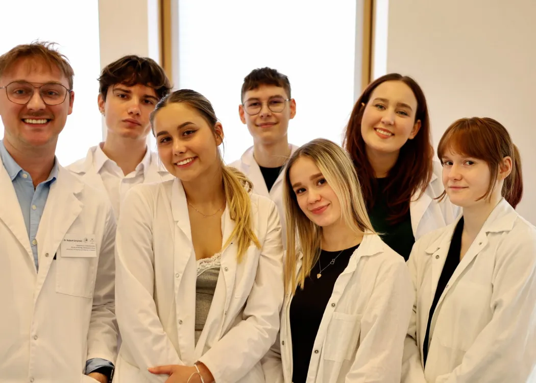 studenci pozują w fartuchach w laboratorium