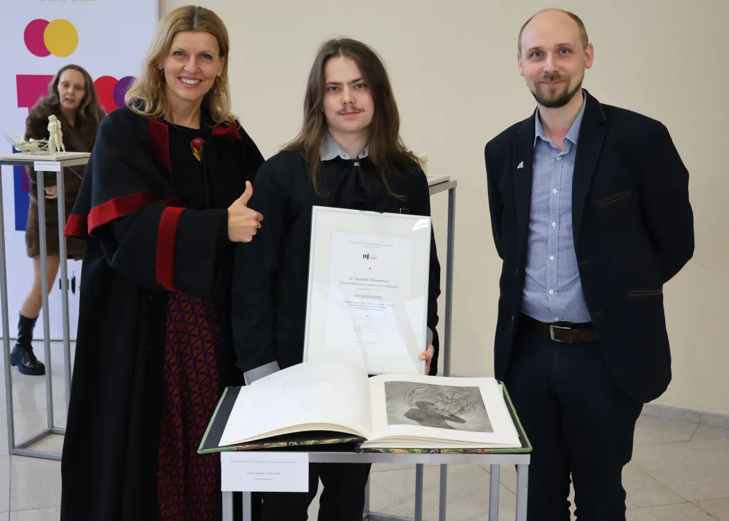 Dyplomatorium Wydziału Sztuki 2025: wyróżniony student pozuje do zdjęcia z rodzicami 