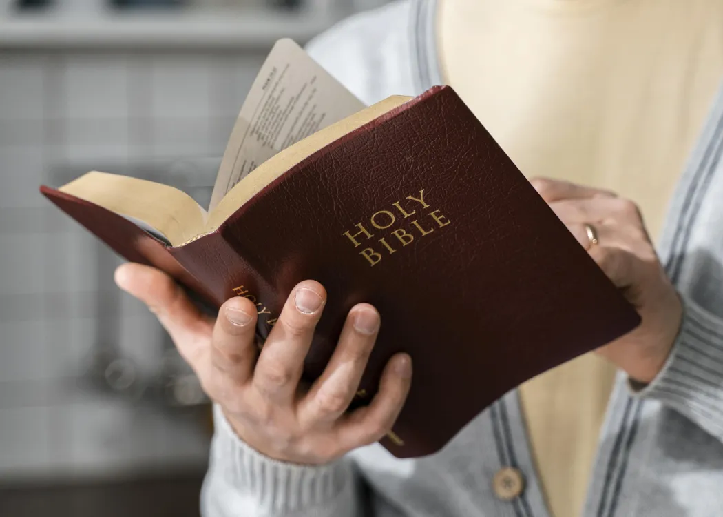 Osoba trzyma Biblię w dłoni, fot. pixabay.com