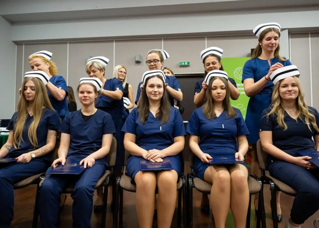 Dyplomatorium SZP: pielęgniarki przypinają dziewczynom czepki