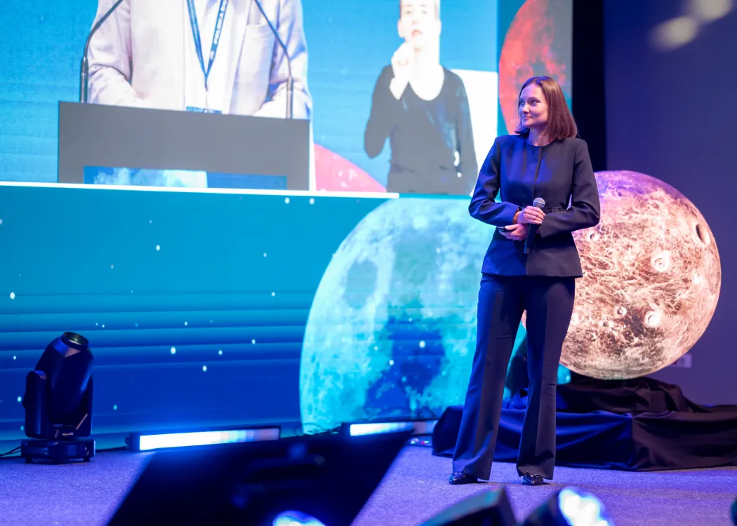 Spotkanie ze Sławoszem Uznańskim-Wiśniewskim na UWM: jedna z prelegentek stoi na scenie