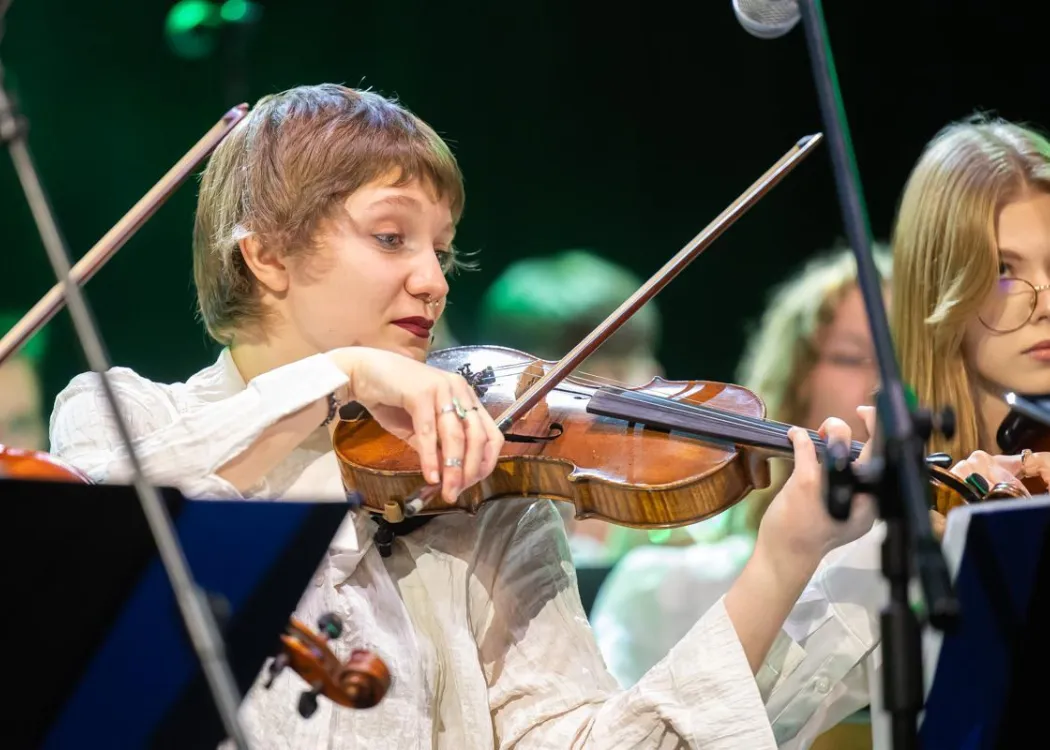 Koncert Kultura pod choinkę 2025: muzyk Orkiestry Akademickiej UWM gra na skrzypcach