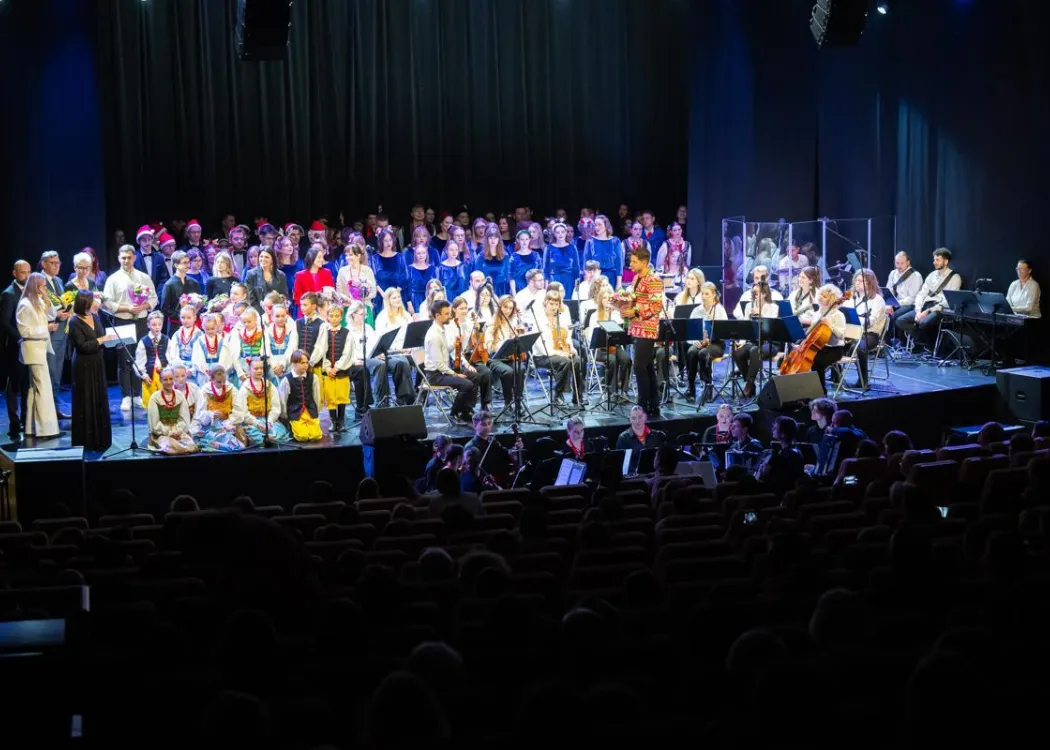 Koncert Kultura pod choinkę 2025: wszyscy uczestnicy koncertu stoją na scenie i wspólnie wykonują utwór