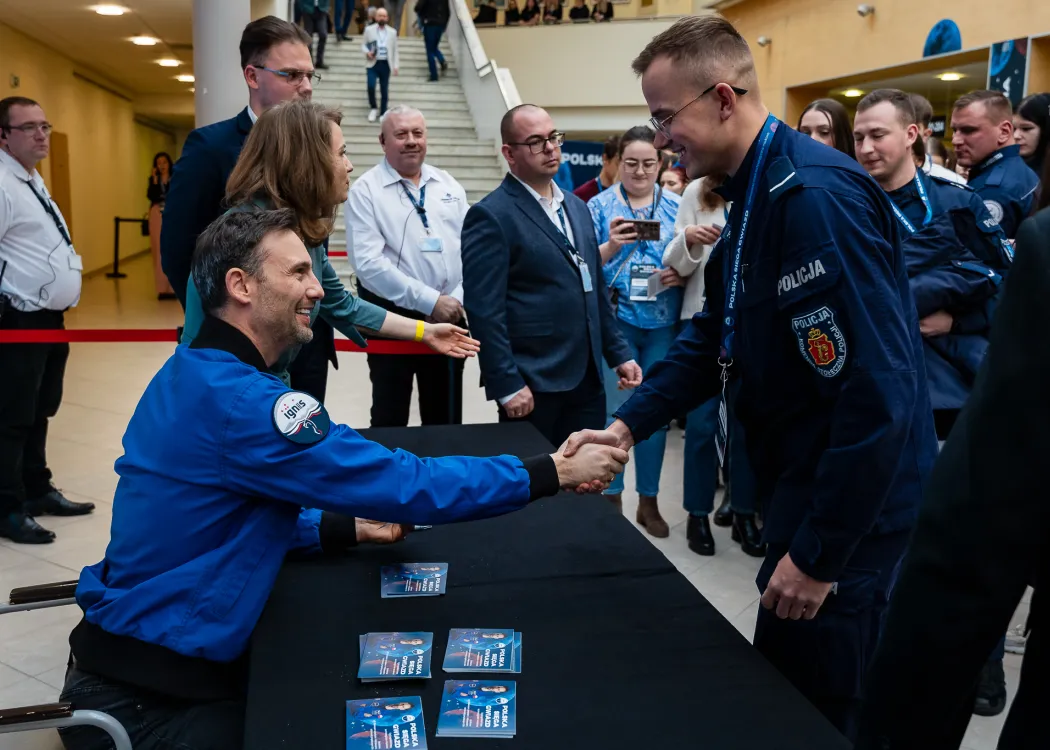 Spotkanie ze Sławoszem Uznańskim-Wiśniewskim na UWM: Sławosz Uznański-Wiśniewski podaje rękę policjantowi