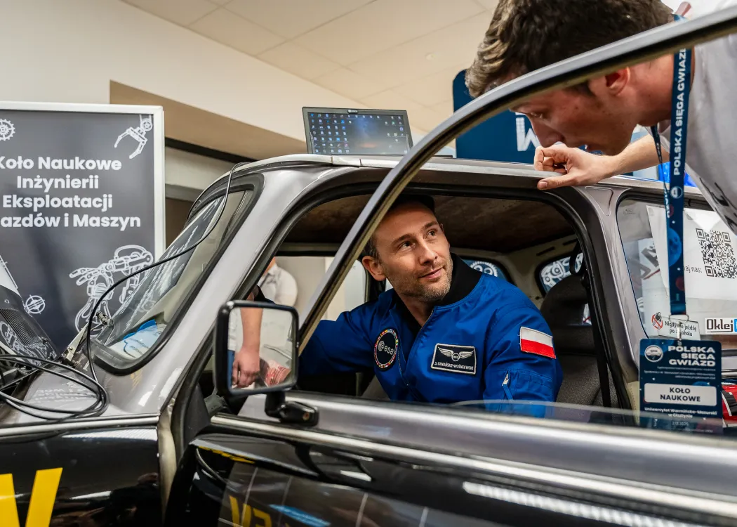 Spotkanie ze Sławoszem Uznańskim-Wiśniewskim na UWM: Sławosz Uznański-Wiśniewski siedzi w samochodzie pokazowym