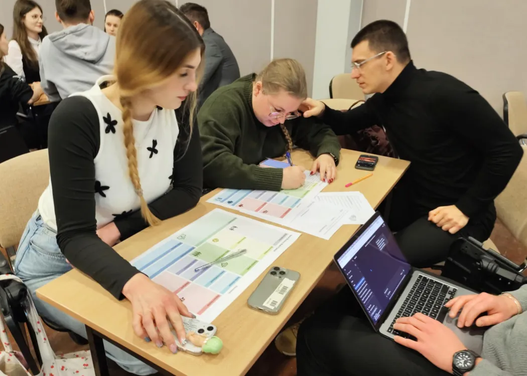 studenci siedzą i omawiają plan biznesowy przedsiębiorstwa społecznego