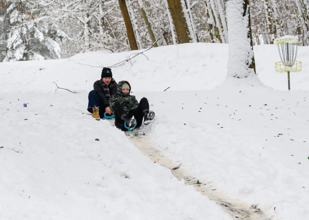 dwie osoby zjeżdżające na jabłku w Kortowie 