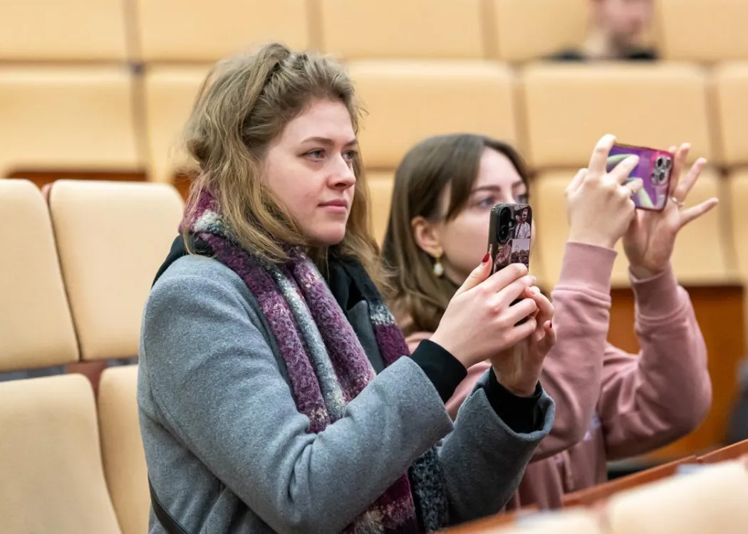 dwie studentki robią trzymają telefony komórkowe 
