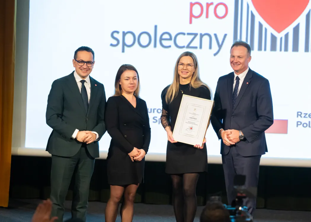 wyróżnieni przez marszałka stoją na scenie i trzymają dyplomy