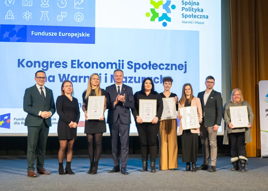 wyróżnieni przez marszałka stoją na scenie i trzymają dyplomy