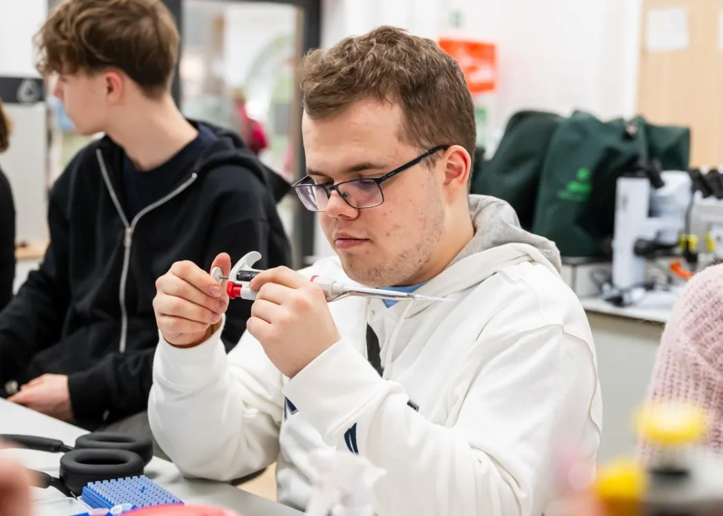 Noc Biologów 2026: uczestnik trzyma przyrząd laboratoryjny 