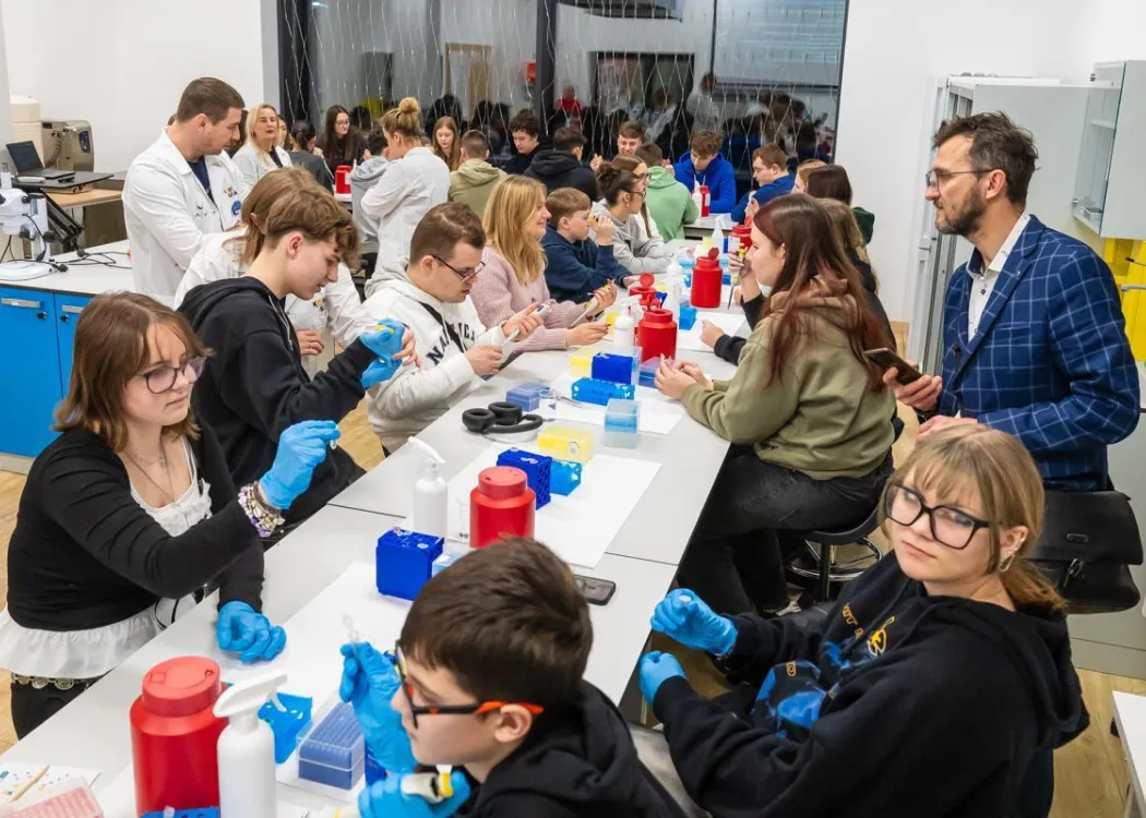 Noc Biologów 2026: uczestnicy przy stole w laboratorium 