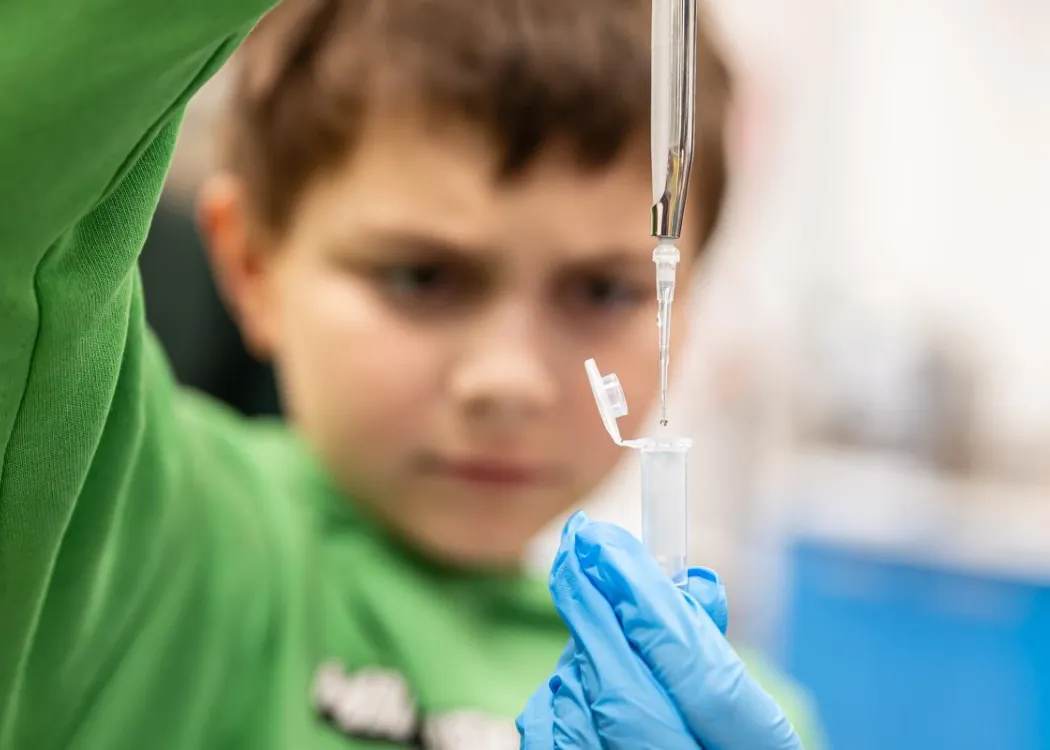 Noc Biologów 2026: chłopiec z pipetą i próbówką  