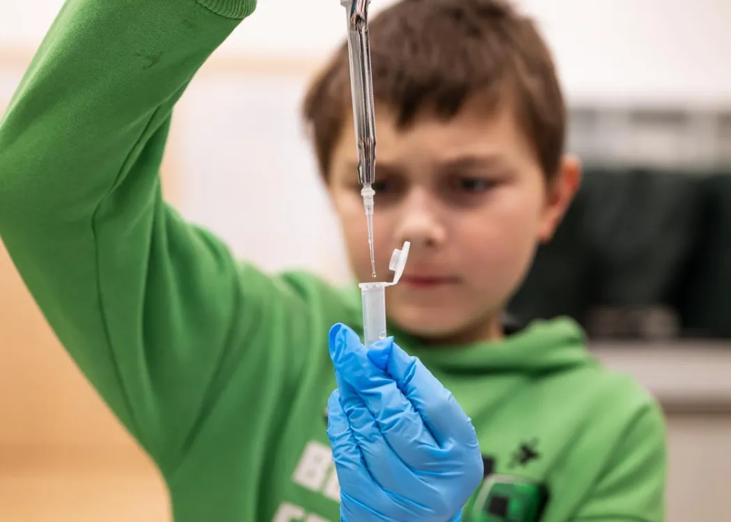 Noc Biologów 2026: chłopiec z pipetą i próbówką