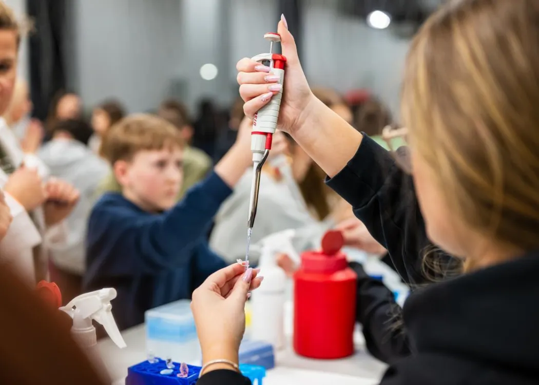 Noc Biologów 2026: uczestniczka naciska na przyrząd w laboratorium 