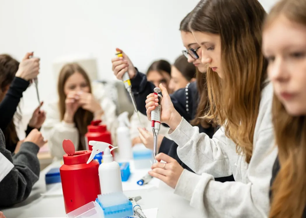 Noc Biologów 2026: uczestnicy zajęć siedzą przy stole w laboratorium