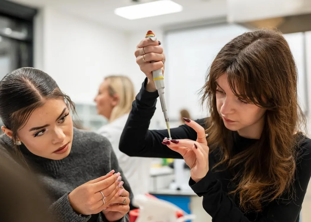 Noc Biologów 2026: uczestnicy zajęć siedzą przy stole w laboratorium