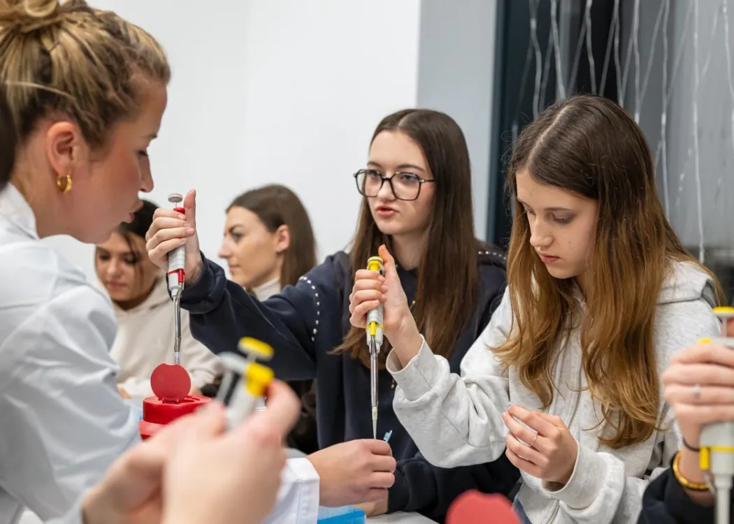Noc Biologów 2026: uczestnicy zajęć siedzą przy stole w laboratorium