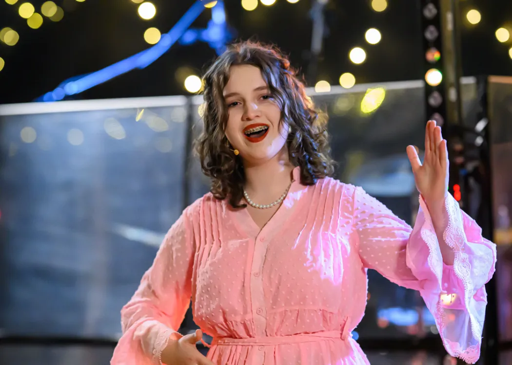 Studentka śpiewa arię i wykonuje ruchy niczym lalka