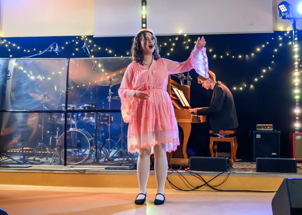 Studentka śpiewa arię i wykonuje ruchy niczym lalka