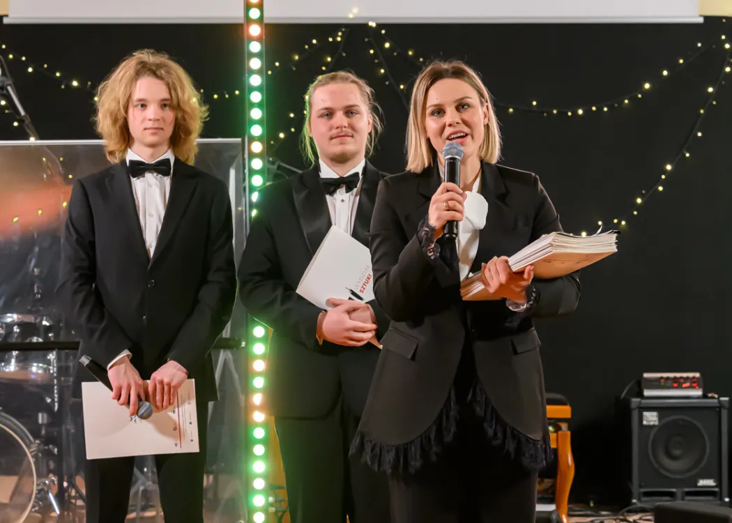 mgr Patrycja Kunert stoi na scenie i dziękuje za udział w Estradzie Studenckiej, obok konferansjerzy