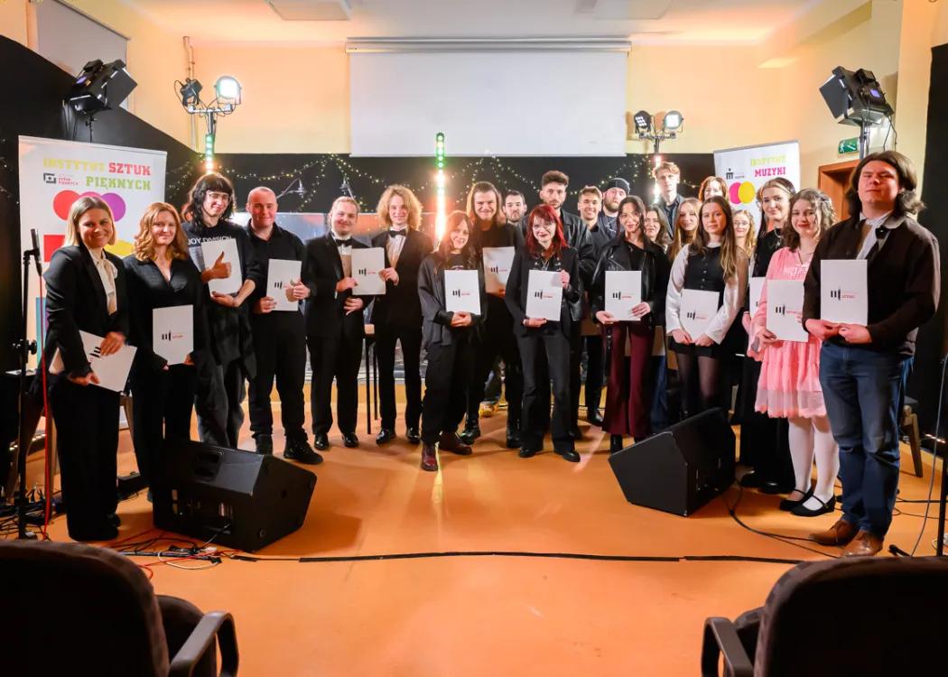 nagrodzeni dyplomami studenci Wydziału Sztuki pozują na scenie