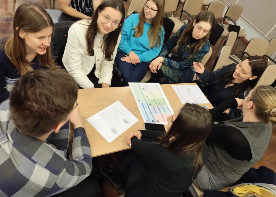 studenci siedzą i omawiają plan biznesowy przedsiębiorstwa społecznego