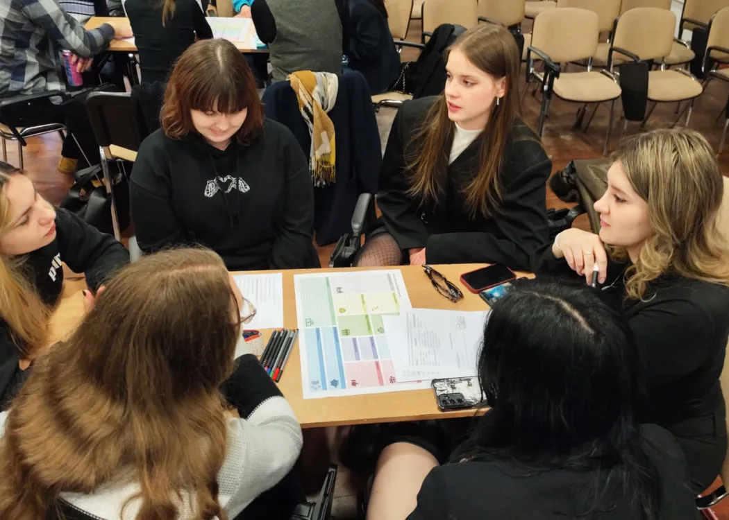 studenci siedzą i omawiają plan biznesowy przedsiębiorstwa społecznego