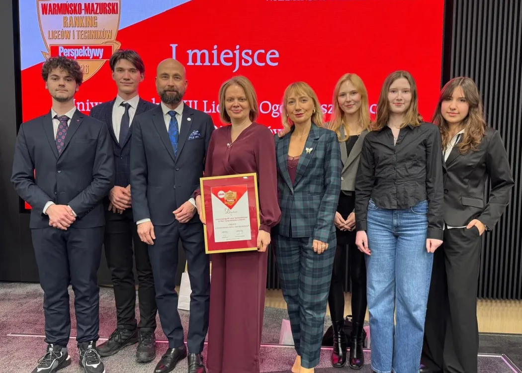 Dyrekcja i uczniowie Uniwersyteckiego XII LO pozują wspólnie z prof. Sławomirem Przybylińskim, prorektorem UWM do zdjęcia. Dyrektorka szkoły Dorota Linkiewicz trzyma w ręku dyplom